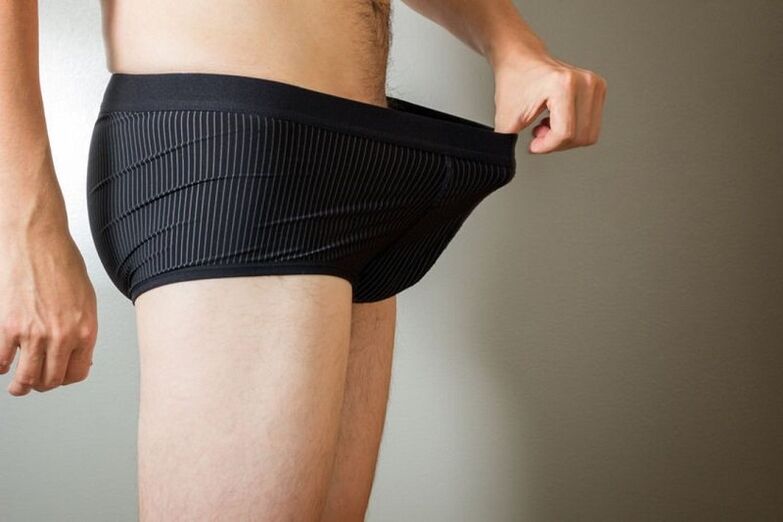 A man looks down his pants and wants to enlarge his penis with lemonade